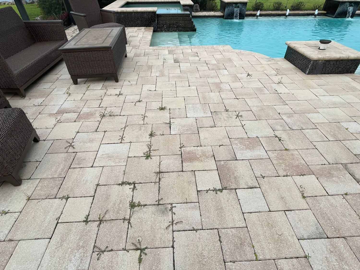 Dirty paved pool deck before pressure washing