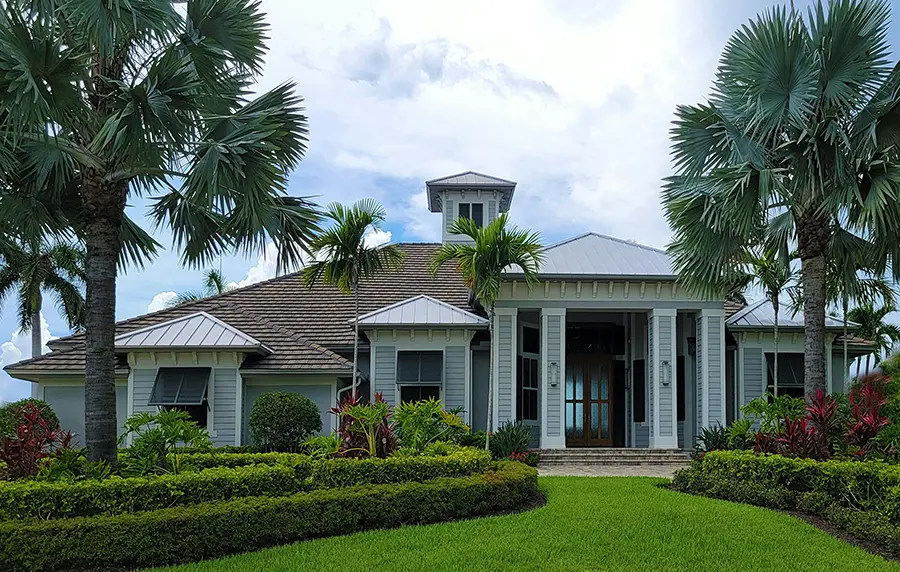 Luxury modern house in Florida surrounded by landscaping and palm trees.